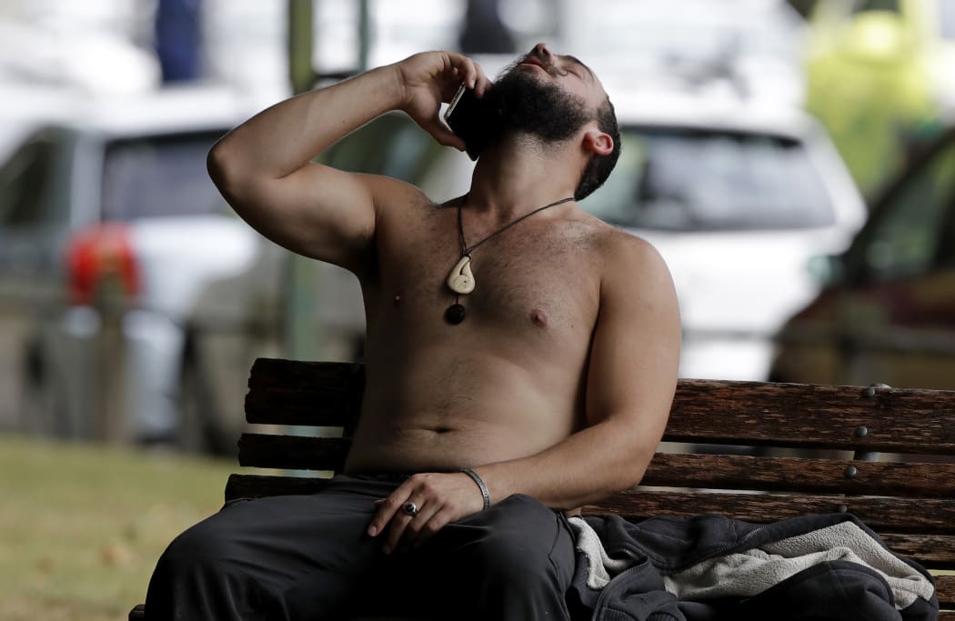 A man reacts as he speaks on a mobile phone outside a mosque in central Christchurch, New Zealand, Friday, March 15, 2019. A witness says many people have been killed in a mass shooting at a mosque in the New Zealand city of Christchurch.(AP Photo/Mark Baker)