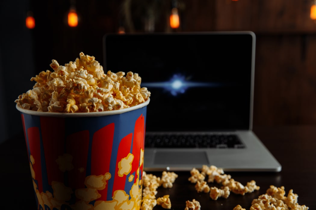 Watching movies on laptop with popcorn.