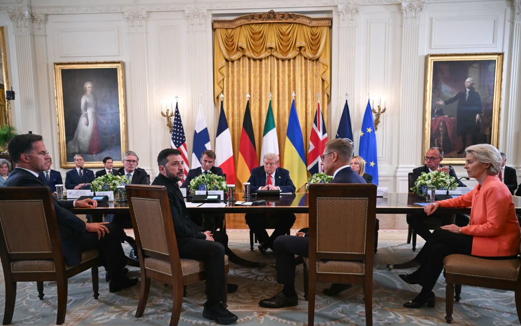 (L/R) NATO Secretary-General Mark Rutte, British Prime Minister Keir Starmer, Ukrainian President Volodymyr Zelensky, French President Emmanuel Macron, US President Donald Trump, Finnish President Alexander Stubb, Italian Prime Minister Giorgia Meloni, German Chancellor Friedrich Merz, and European Commission President Ursula von der Leyen participate in a meeting in the East Room of the White House in Washington, DC, on August 18, 2025. European leaders join Ukrainian President Volodymyr Zelensky in talks with US President Donald Trump on August 18, as they try to find a way to end Russia's offensive.  The leaders heading to Washington on Monday to appear alongside Zelensky call themselves the "coalition of the willing." (Photo by ANDREW CABALLERO-REYNOLDS / AFP)