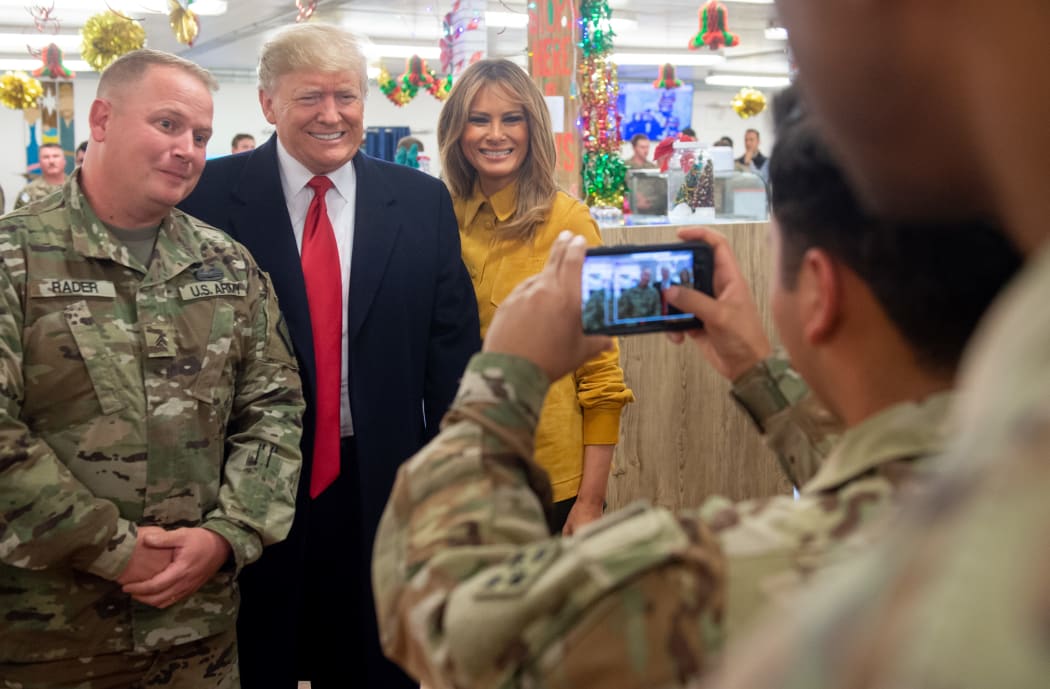 US President Donald Trump and First Lady Melania Trump take photos with members of the US military during an unannounced trip to Al Asad Air Base.