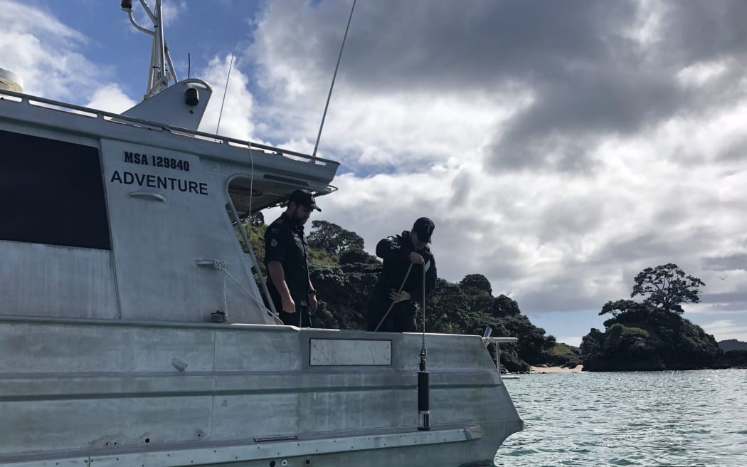 Leading Hydrographic Systems Technician Ryan Hulse (left) supervises Able Chef Dominique Telfar-Valks as she conducts a sound velocity profile.