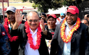 Papua New Guinea's prime minister Peter O'Neill  (with glasses) celebrates being declared winner of the election in his Ialibu-Pangia electorate, alongside fellow victorious People's National Congress member James Marape (red hat).