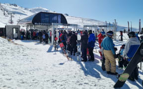Skiiers and snowboarders line up at Cardrona Alpine Resort.