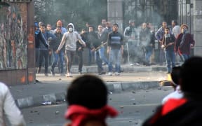 Muslim Brotherhood supporters (background) clash rival pro-government demonstrators in Cairo on Saturday.