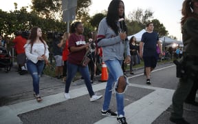Students walk to Marjory Stoneman Douglas High School as they attend classes for the first time since the shooting that killed 17 people.