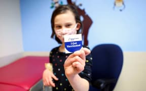 DENVER, CO - NOVEMBER 03: Margaret Sponsler, 7, holds out a sticker after receiving a dose of the pediatric COVID-19 vaccine at National Jewish Health on November 3, 2021 in Denver, Colorado.