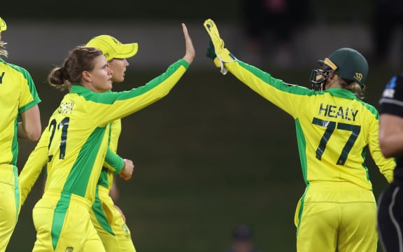 Australia's Jess Jonassen (L) celebrates White Ferns Amelia Kerr being caught with team mate  wicket keeper Alyssa Healy