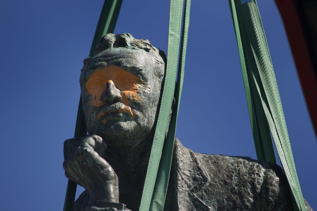 The defaced statue being removed