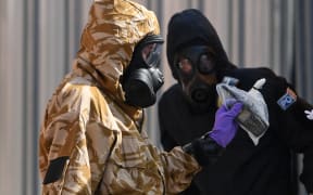 An investigators in protective suits in Rollestone Street on 6 July, 2018 after a man and woman were found unconscious in a novichok attack.