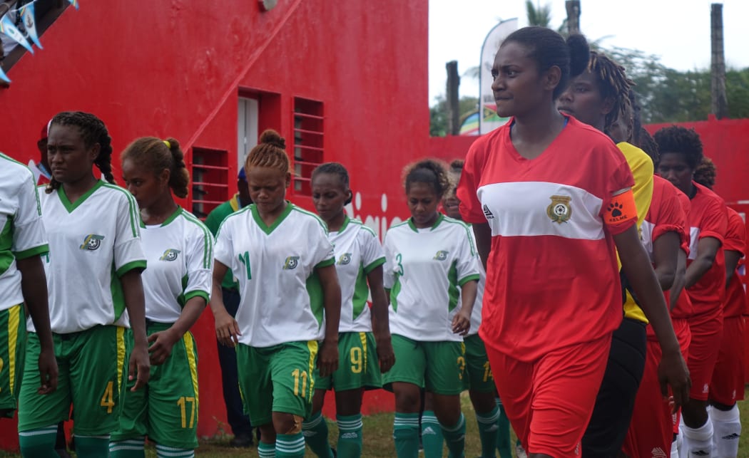 The Solomons and Vanuatu, (in red), teams walk out for their Mini Games clash