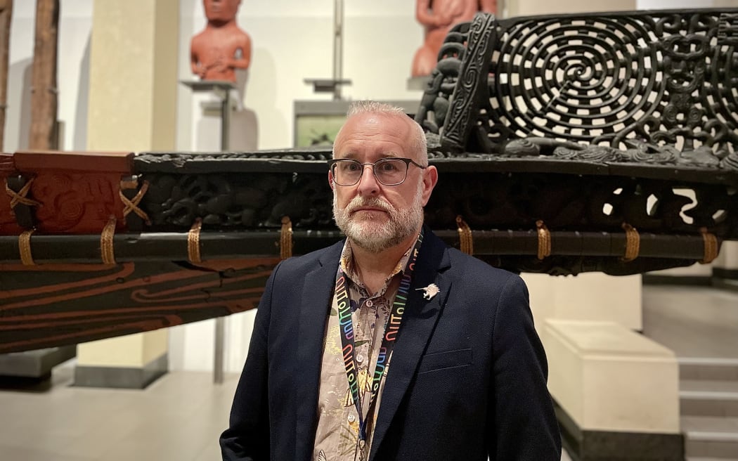David Reeves stands in front of Te Toki-a-Tāpiri waka on display in the Auckland War Memorial Museum.