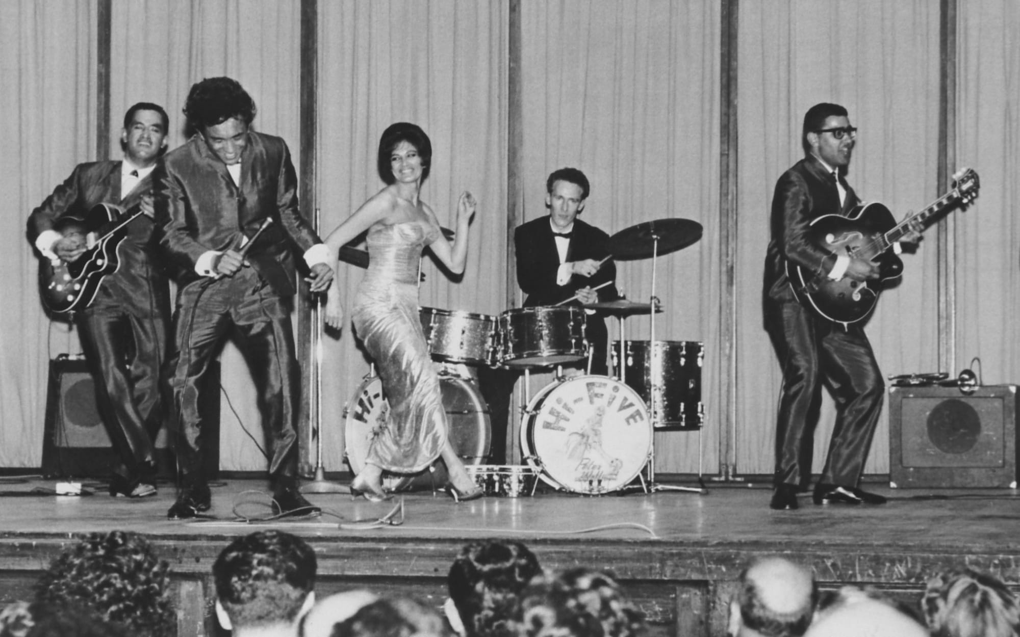 The Hi-Fives perform at the Wellington Town Hall in 1963 after returning from an international tour. From left: Kawana Pohe (saxophone), Paddy Te Tai (guitar), Solomon Pohatu (microphone), Mere Nimmo (singer), Peter Wolland (drums), Rob Hemi (guitar) and Wes Epae (bass).