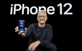 In this photo released by Apple, Apple CEO Tim Cook holds up the all-new iPhone 12 Pro.