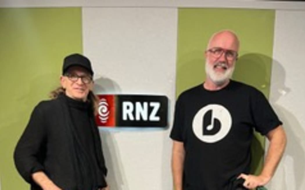 Trevor Reekie and Joost Langeveld pose in front of the RNZ sign at RNZ Auckland