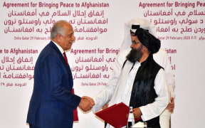US Special Representative for Afghanistan Reconciliation Zalmay Khalilzad and Taliban co-founder Mullah Abdul Ghani Baradar shake hands after signing a peace agreement during a ceremony in the Qatari capital Doha on February 29, 2020
