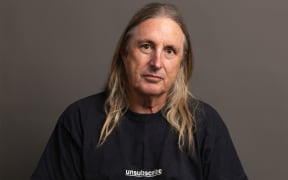 The writer Tim Winton has long hair and a black t-shirt with the word 'unsubscribe'