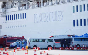 Passenger patients on board the Princess Diamond,  who have tested positive for the novel coronavirus are carried to an ambulance at the Yokohama port.