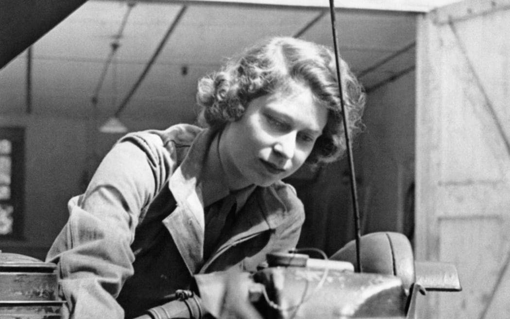 Princess Elizabeth taking out the plugs of a car during training at an A.T.S training centre, in Southern England, in 1945.