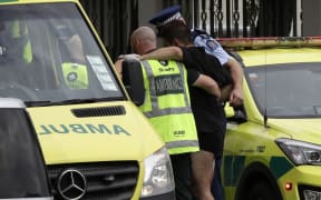 Police and ambulance staff help a wounded man from outside a mosque in central Christchurch, New Zealand, Friday, March 15, 2019.  A witness says many people have been killed in a mass shooting at a mosque in the New Zealand city of Christchurch. (AP Photo/Mark Baker)