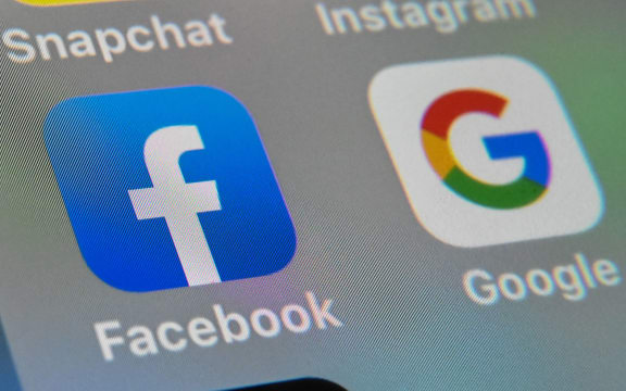 A picture taken on October 1, 2019 in Lille shows the logos of mobile apps Facebook and Google displayed on a tablet. (Photo by DENIS CHARLET / AFP)