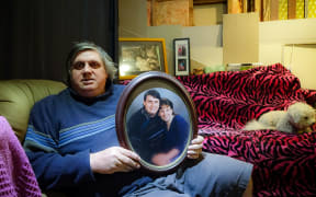 Laurie Anderson with an old photo of him and his partner Angela Blackmoore, who was murdered in their home 20 years ago.