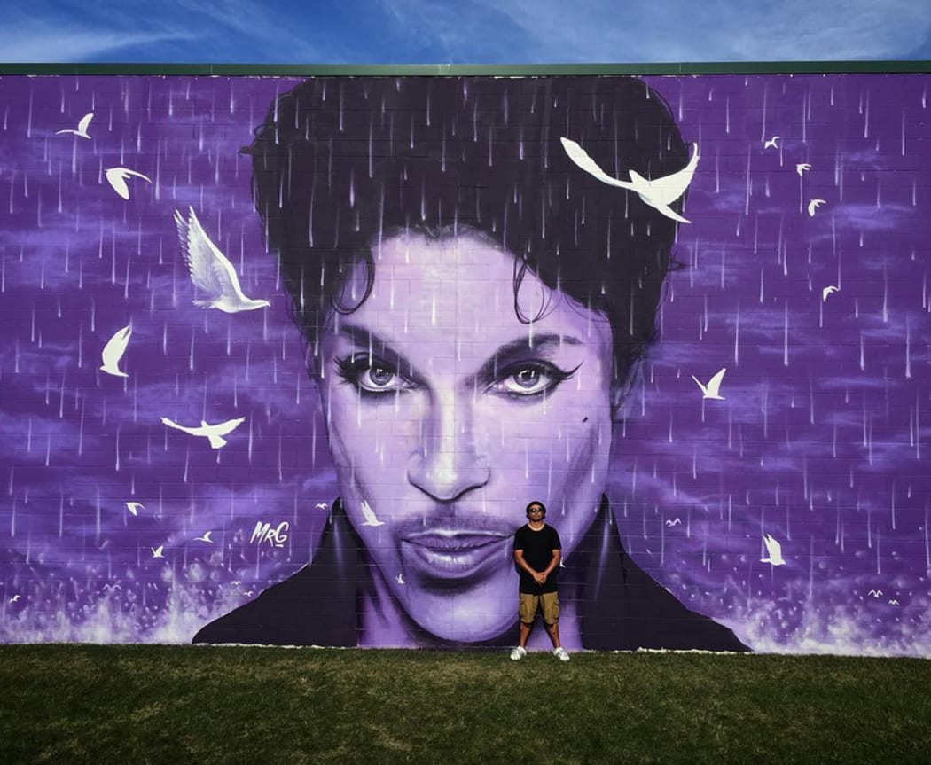 Artist Graham Hoete with his massive Prince wall mural.