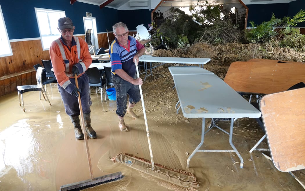 Ōakura Bay Reserves Board member Malcolm Devereux, left, and chairman Glenn Ferguson start the cleanup of the devastated Ōakura Hall.