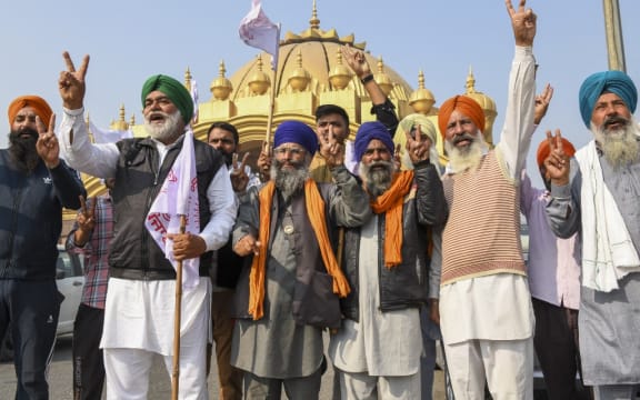 Farmers shout slogans to celebrate after India's Prime Minister announced to repeal three agricultural reform laws that sparked almost a year of huge protests across the country in Amritsar on November 19, 2021.