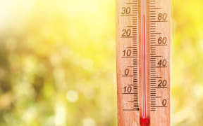 Thermometer displaying high 30 degree hot temperatures in sun summer day