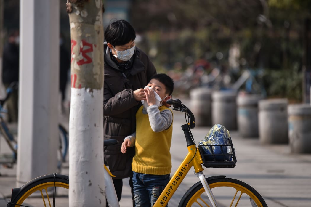A woman cleans a boy's face in Wuhan,  Hubei province. The number of confirmed cases in the new virus outbreak in China reached 5,974 on 29 January.