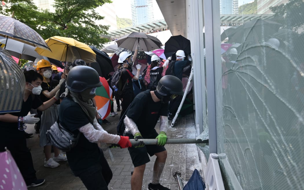 Protesters attempt to break a window at the government headquarters in Hong Kong.