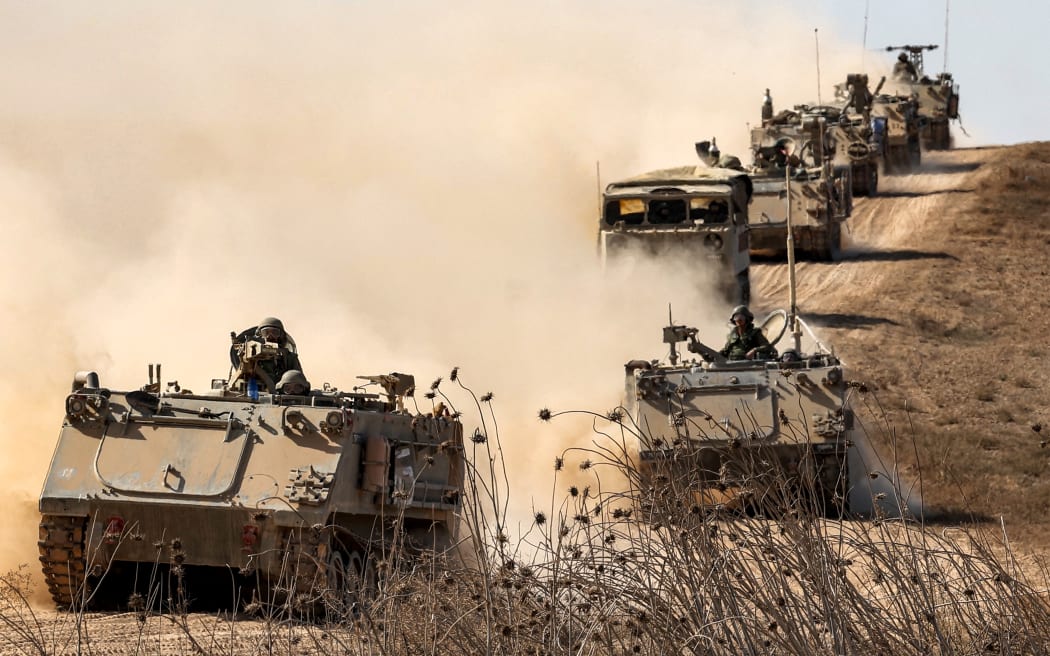 Israeli army infantry fighting vehicles (IFVs) deploy along the border with the Gaza Strip in southern Israel on 13 October, 2023. Thousands of people, both Israeli and Palestinians have died since October 7, 2023, after Palestinian Hamas militants entered Israel in a surprise attack leading Israel to declare war on Hamas in the Gaza Strip enclave on 8 October.