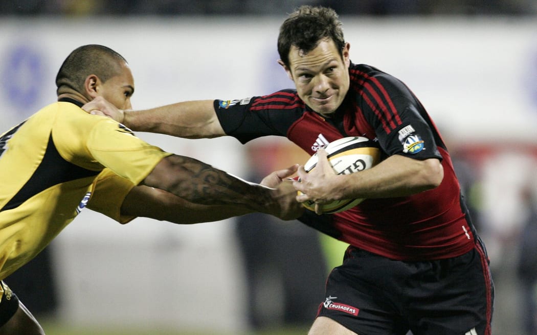 Leon MacDonald, with the Crusaders in 2008, fends off the Hurricanes' Hosea Gear.