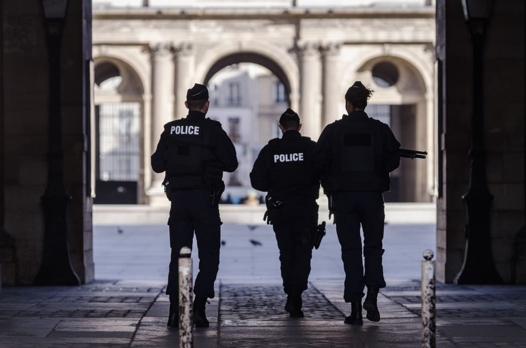 Police secure the area in front of the Louvre.