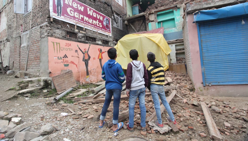 Children look towards a damaged residential structure in Srinagar, the summer capital of Indian-controlled Kashmir.