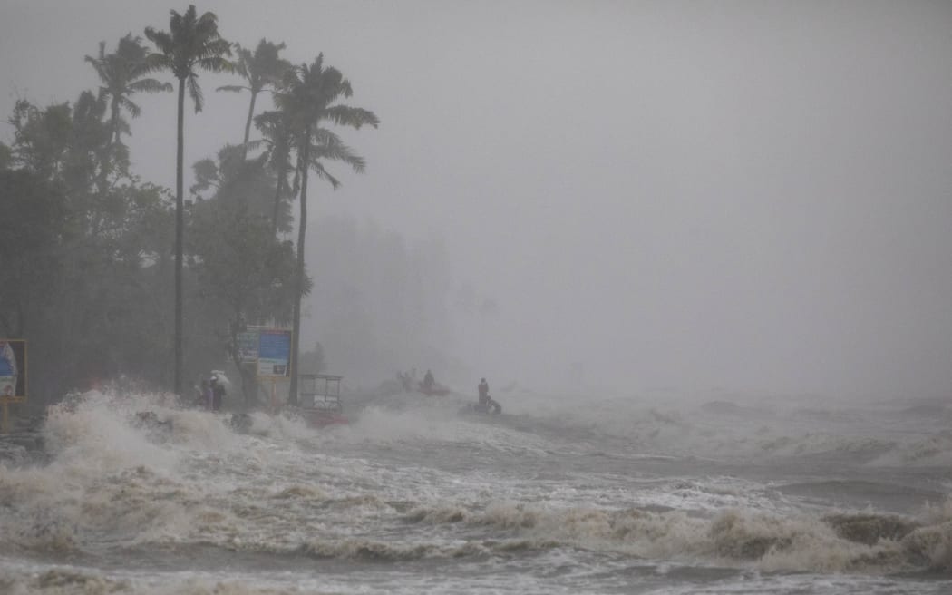 People take shelter from heavy rain at Kuakata Sea coast ahead of cyclone Remal's landfall in Kuakata, Bangladesh, on May 26, 2024. According to local authorities, an intense cyclone smashed into the low-lying coast of Bangladesh on Sunday, and at least 800,000 people evacuated their homes in low-lying coastal areas of Bangladesh as the intense cyclone made landfall. (Photo by K M Asad / Middle East Images / Middle East Images via AFP)