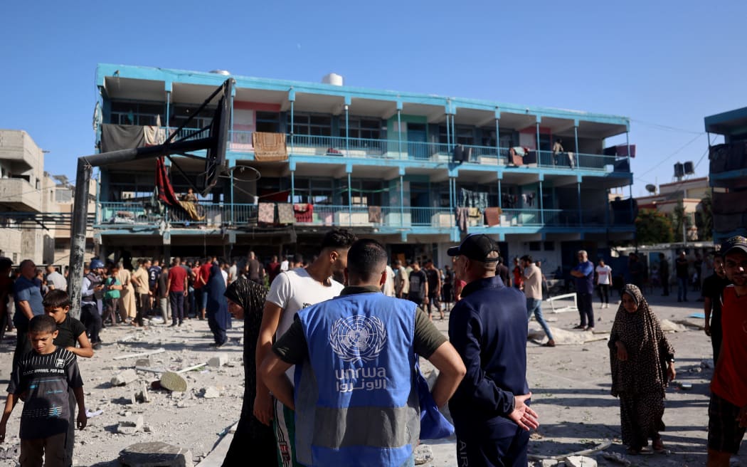 A member of the United Nations Relief and Works Agency for Palestine Refugees (UNRWA) checks the courtyard of the Al-Jawni (Jaouni) school after an Israeli air strike hit the site, in Nuseirat in the central Gaza Strip on September 11, 2024, amid the ongoing war in the Palestinian territory between Israel and Hamas. An Israeli air strike on September 11 hit a central Gaza school, with the Hamas-run territory's civil defence agency reporting 10 killed in the facility turned displacement shelter and the military saying it had targeted militants. (Photo by Eyad BABA / AFP)