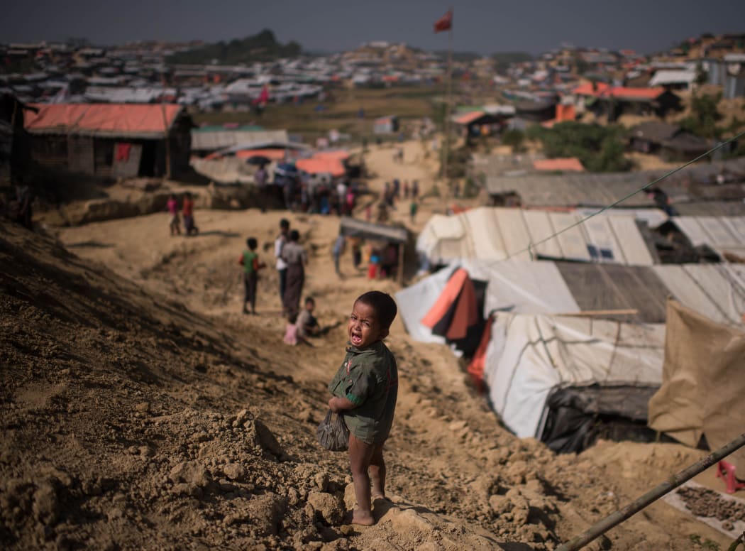 A Rohingya Muslim refugee child cries as he stands near the Thyangkhali refugee camp at Cox's Bazar on November 29, 2017.