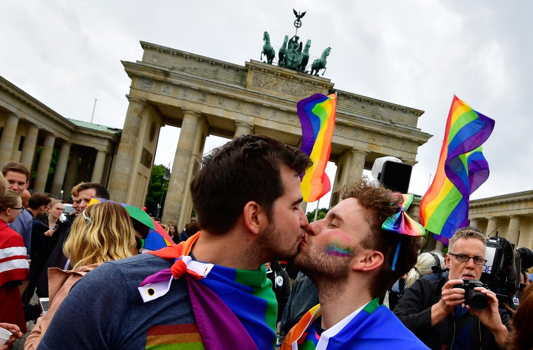 Two men kiss as they attend a rally of gays and lesbians in front of the Brandenburg Gate in Berlin on 30 June, 2017.