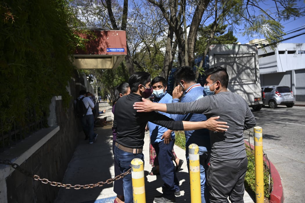 People remain outside the Ministry of Foreign Affairs in Guatemala City on January 25, 2021, after giving details of their relatives who might be in the group among people found burned to death on a rural road in the state of Tamaulipas, Mexico.