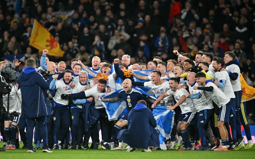 Scotland players celebrate on the pitch after the FIFA World Cup 2026 European qualification football match between Scotland and Denmark at Hampden Park in Glasgow, 2025.