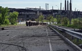 A shot from a Russian Defence Ministry video shows Ukrainian service members walking in line on 17 May as they leave the Azovstal steel plant in Mariupol.