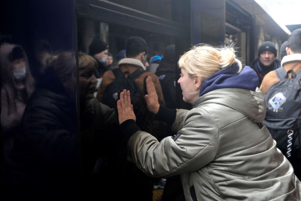 A woman says goodbye as a train with evacuees is about to leave Kyiv's railway station on March 2, 2022. Russia steps up its bombing campaign and missile strikes on Ukraine's cities on March 2, 2022.