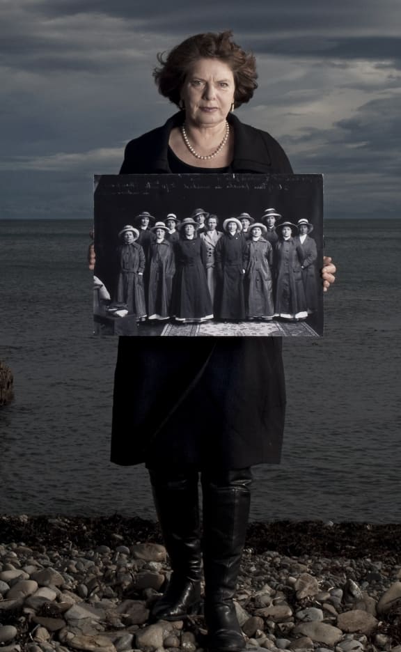 Jane Tolerton holding a photo of the NZ Volunteer Sisterhood before the first group left Wellington for Egypt in October 1915. Hatless in the middle is Ettie Rout, the one woman associated with NZ in WWI whose name is well known.