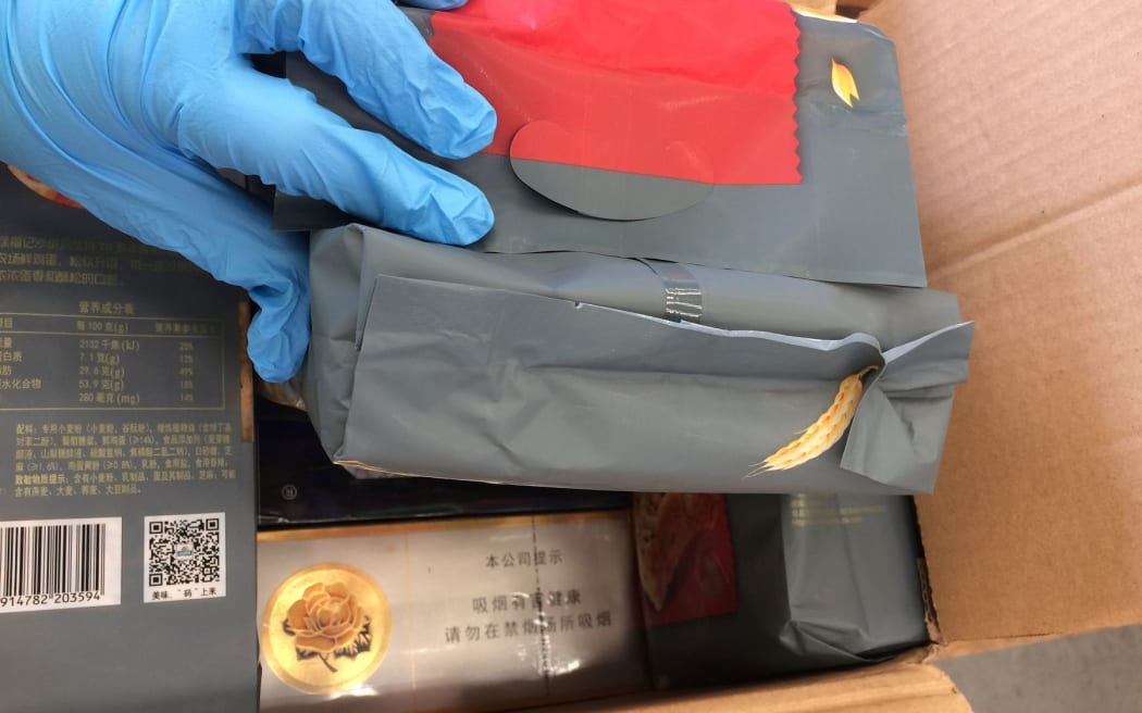 A closeup of cigarettes revealed in an opened box disguised as foodstuffs.