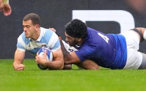 Argentina's wing Emiliano Boffelli (left) scores a try as Samoa's lock Brian Alainu'uese attempts a tackle during the France Rugby World Cup Pool D match at Stade Geoffroy-Guichard in Saint-Etienne, south-eastern France on 22 September, 2023.