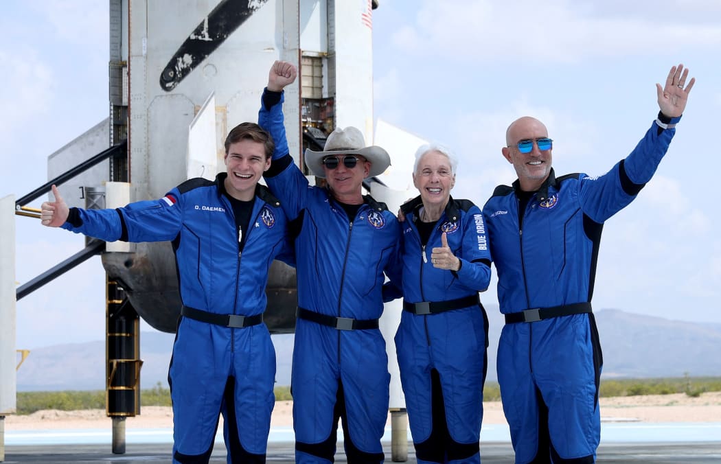 Blue Origin's New Shepard crew (L-R) Oliver Daemen, Jeff Bezos, Wally Funk, and Mark Bezos pose for a picture near the booster after flying into space in the Blue Origin New Shepard rocket on 20 July 20, 2021 in Van Horn, Texas.