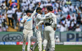 New Zealand's Glenn Phillips (2R) celebrates with teammates after taking the wicket of India's Washington Sundar during the third day of the second Test cricket match between India and New Zealand at the Maharashtra Cricket Association Stadium in Pune on October 26, 2024. (Photo by Punit PARANJPE / AFP) / -- IMAGE RESTRICTED TO EDITORIAL USE - STRICTLY NO COMMERCIAL USE --