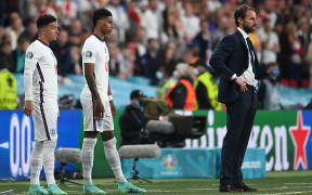 England's forward Jadon Sancho (L) and England's forward Marcus Rashford (C) wait to come on during the UEFA EURO 2020 final football match between Italy and England at the Wembley Stadium in London on 11 July 2021.