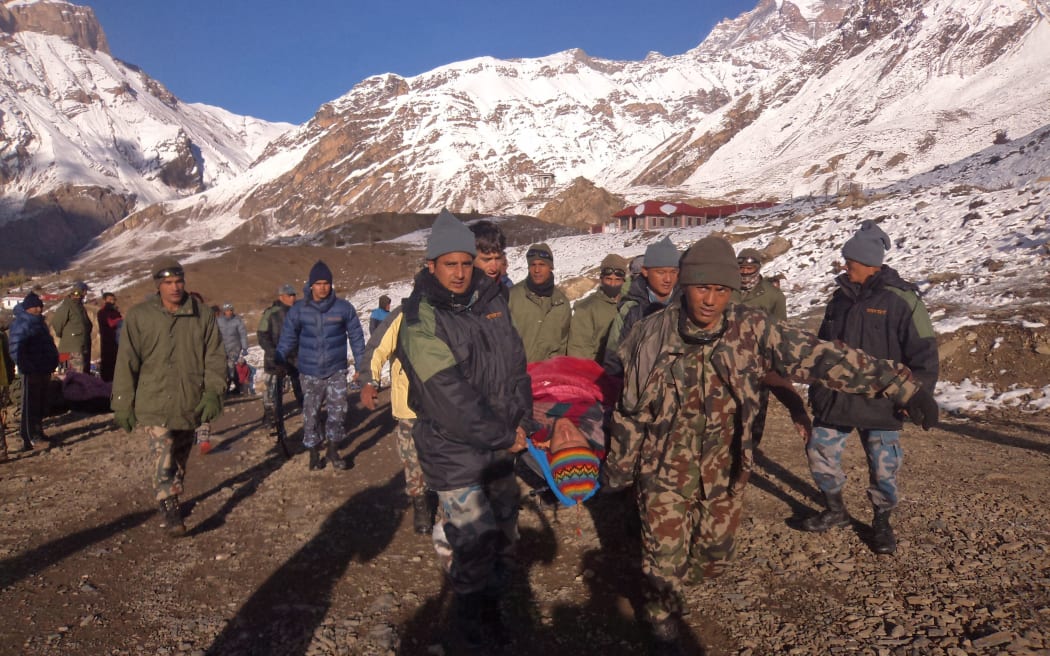 An injured survivor of the snowstorm in the Himalayas is rescued.